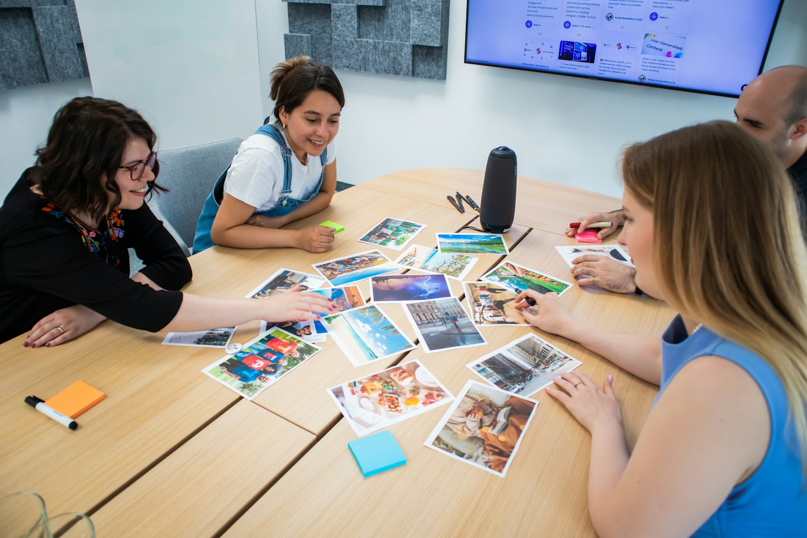Creative team reviewing printed photos and notes around a table